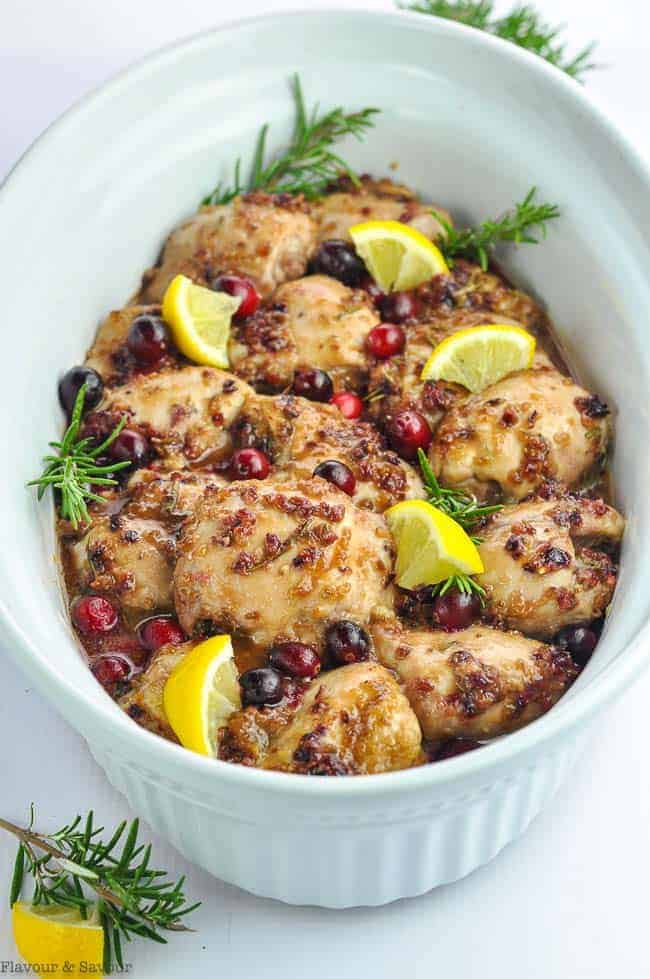 An oval baking dish with Cranberry Rosemary Boneless Chicken Thighs
