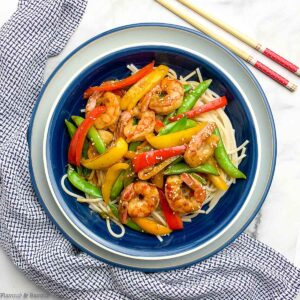 overhead view of a bowl with lemon garlic shrimp stir fry with chopsticks