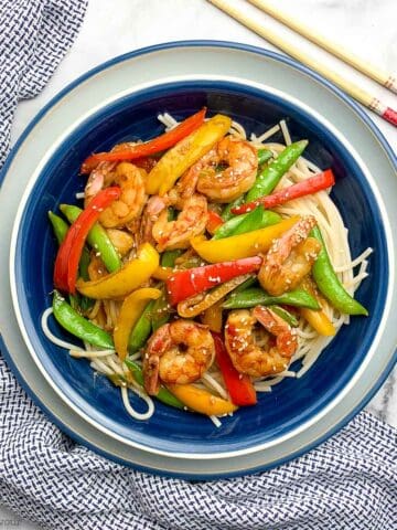 overhead view of a bowl with lemon garlic shrimp stir fry with chopsticks