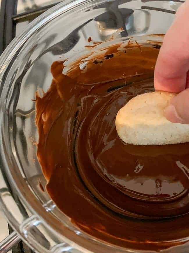 Dipping cookie in melted chocolate