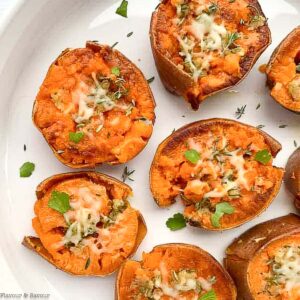 rosemary garlic smashed sweet potatoes on a white serving dish