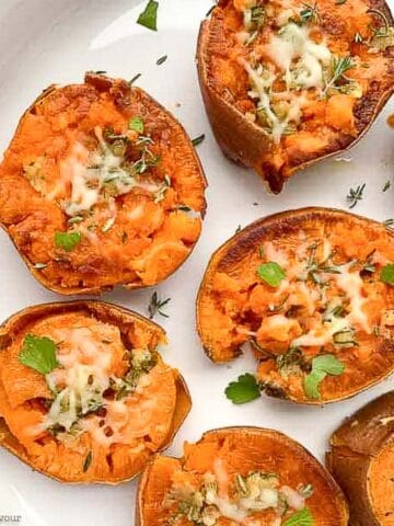 rosemary garlic smashed sweet potatoes on a white serving dish