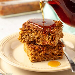 Two squares of pumpkin baked oatmeal with maple syrup