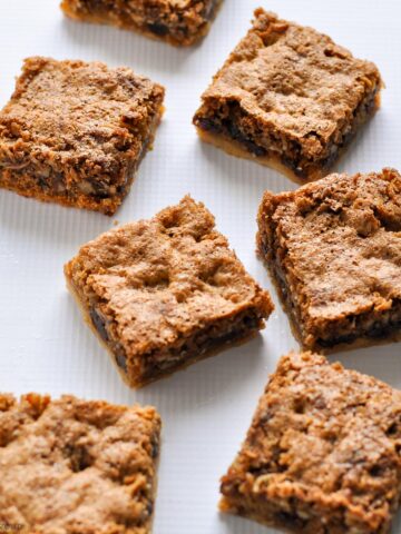 six gluten-free butter tart squares on a white cloth