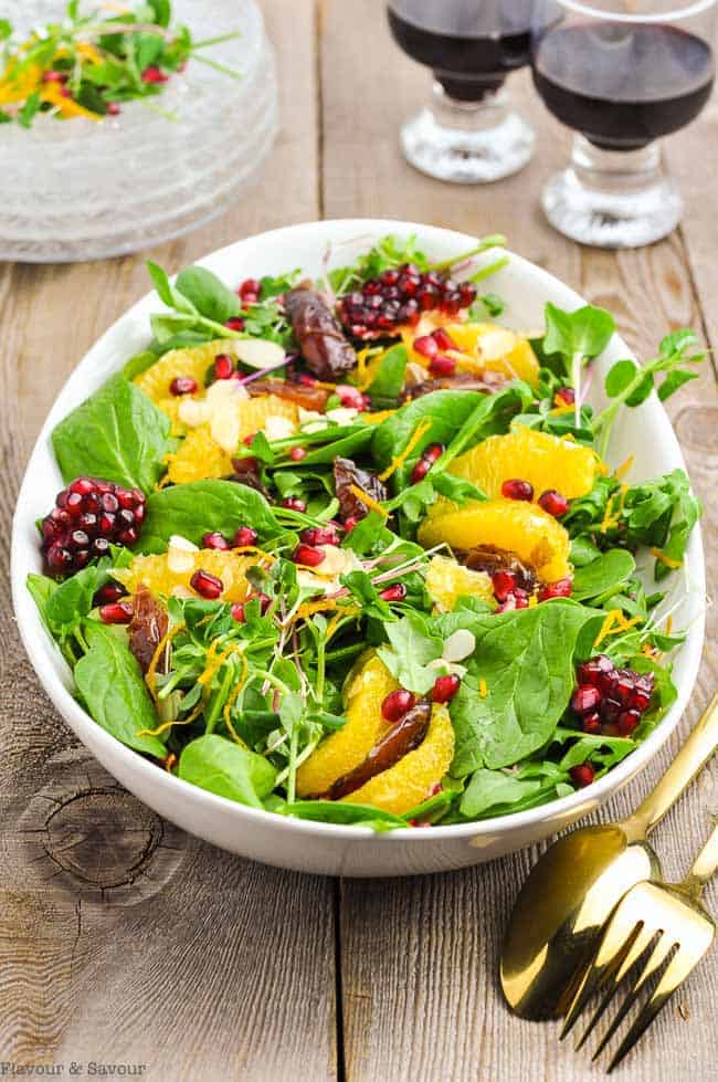 Date and Orange Spinach Salad with two wine glasses