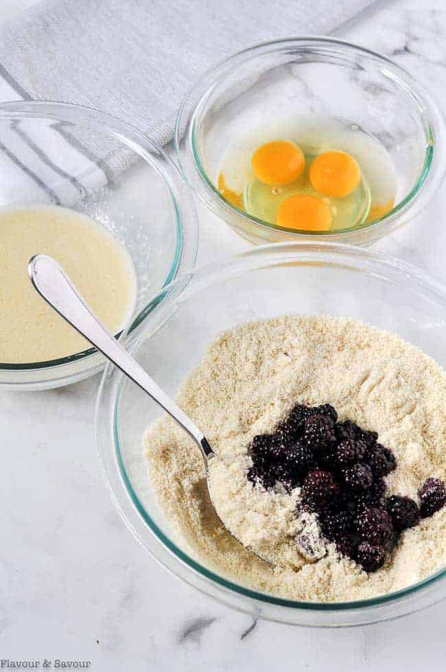 Adding blackberries to dry ingredients.