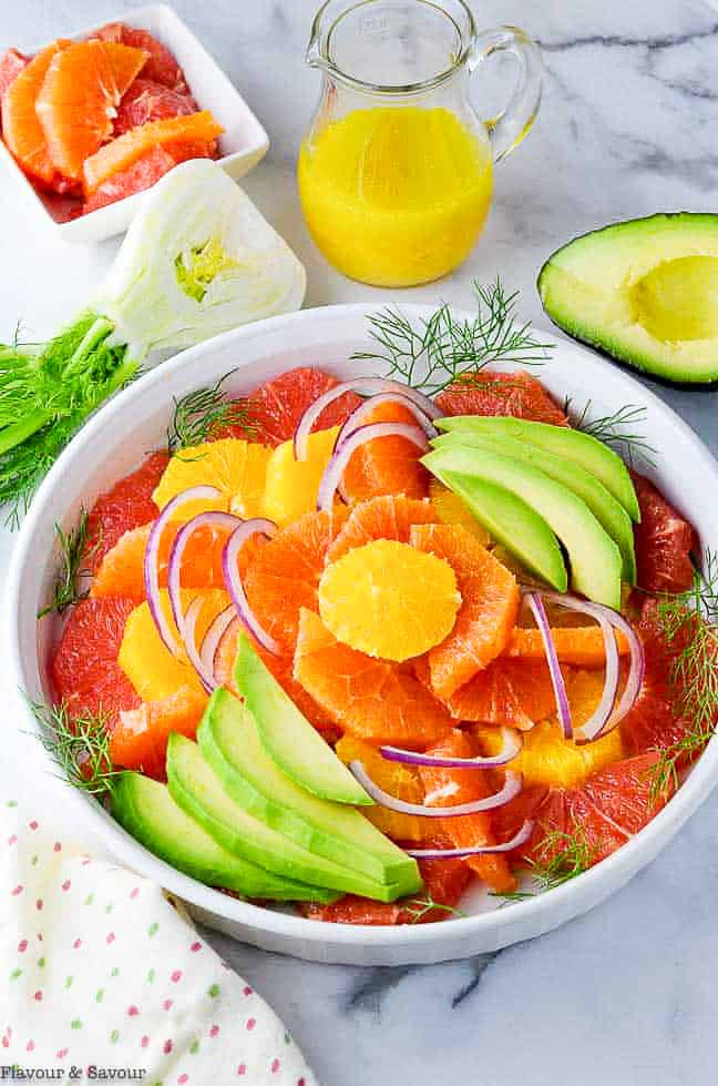 Overhead view of Grapefruit Orange Avocado Salad with a jar of dressing