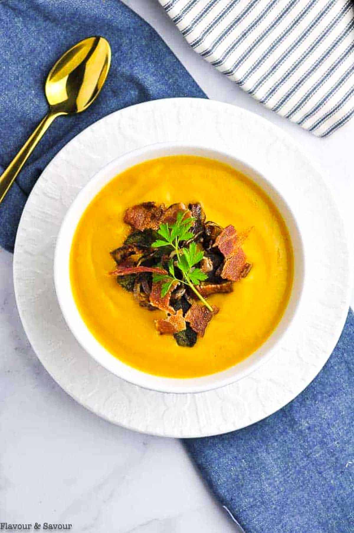 Overhead view of a bowl of butternut squash soup with ginger and orange.