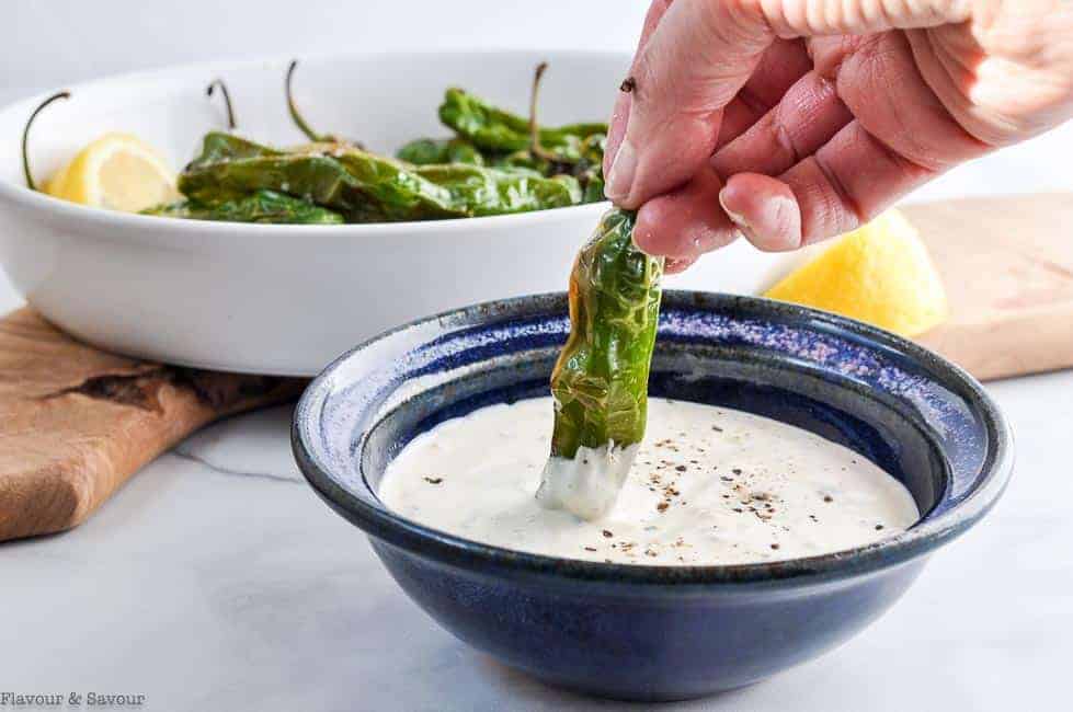 Dipping a Shishito or Padron pepper in lemon aioli