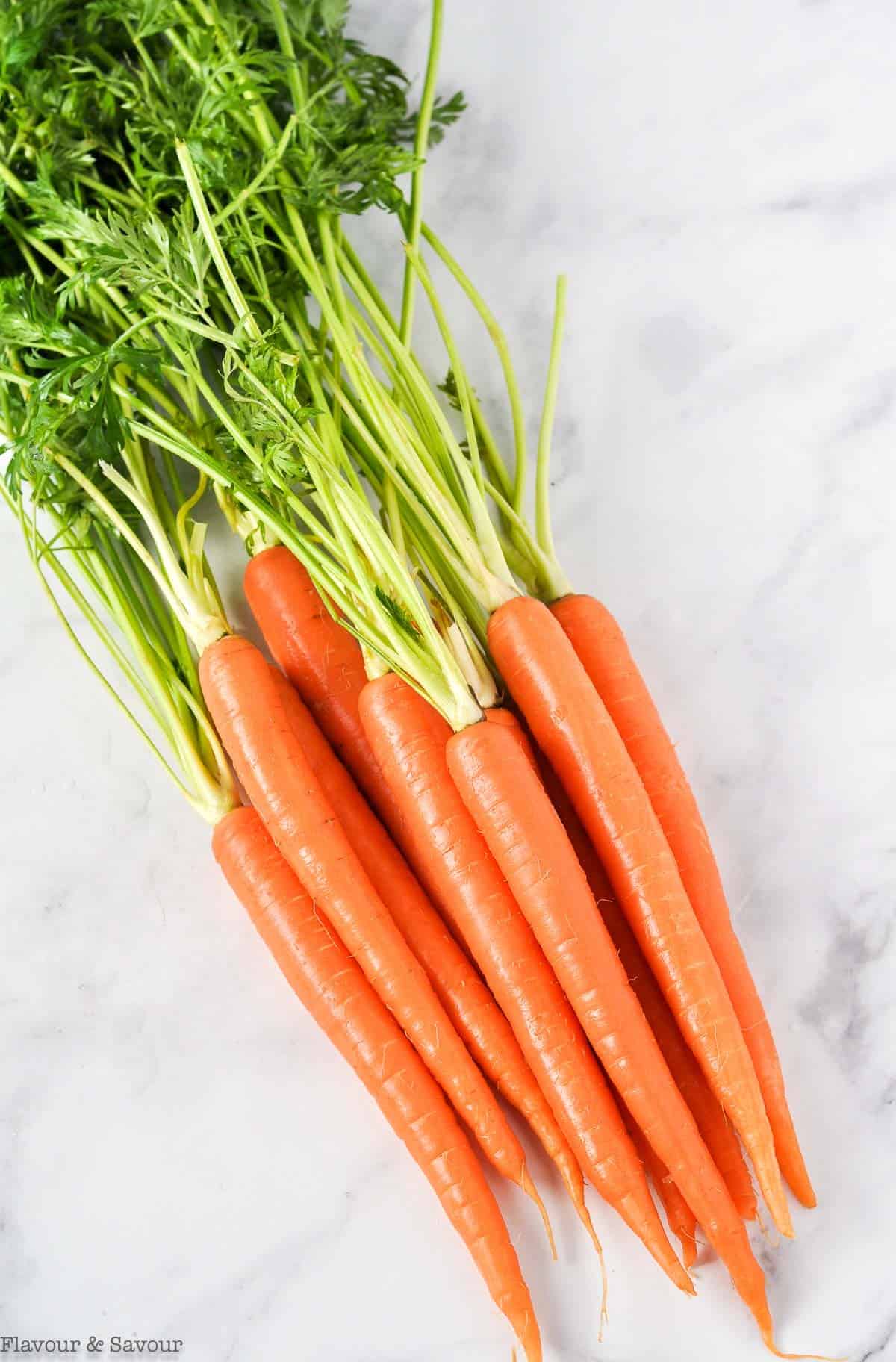 Raw carrots with tops.