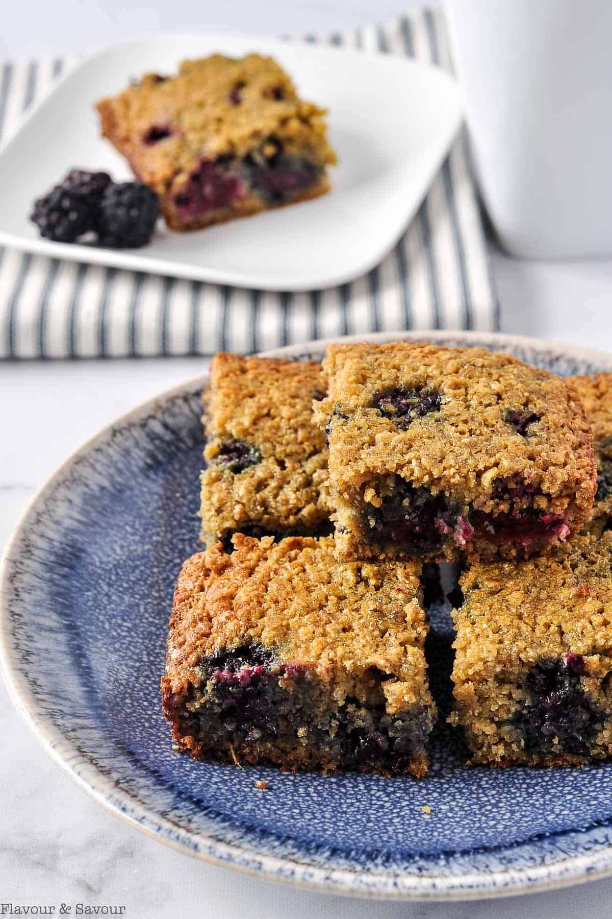 A stack of blackberry oatmeal breakfast bars on a blue stoneware plate.