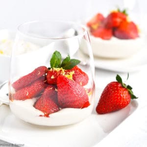 a dessert glass with cashew cream and macerated strawberries