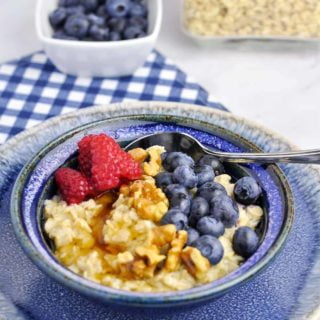 A bowl of oatmeal with blueberries and raspberries