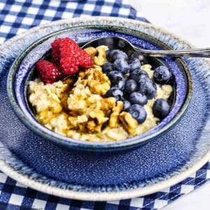 A bowl of oatmeal with blueberries and raspberries.