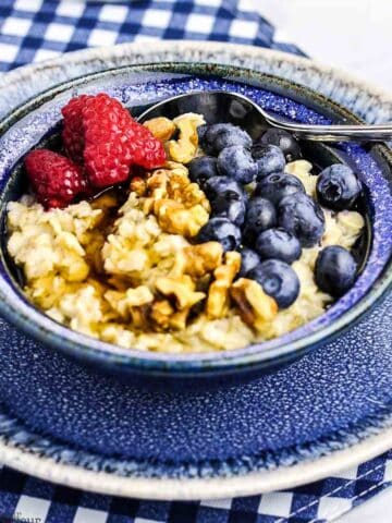 A bowl of oatmeal with blueberries and raspberries.