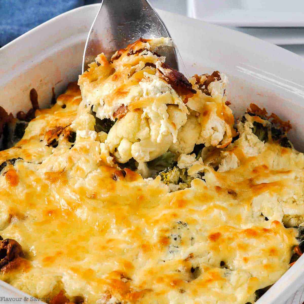 A spoonful of broccoli cauliflower casserole with cheese.