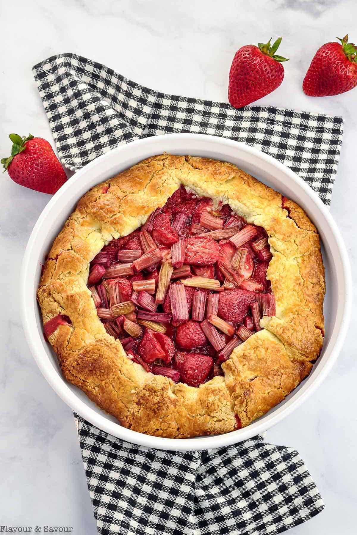 Overhead view of Strawberry Rhubarb Galette on a black and white checkered cloth.