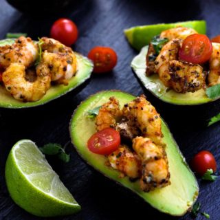 Cajun Shrimp Stuffed Avocados overhead view with cherry tomatoes and limes