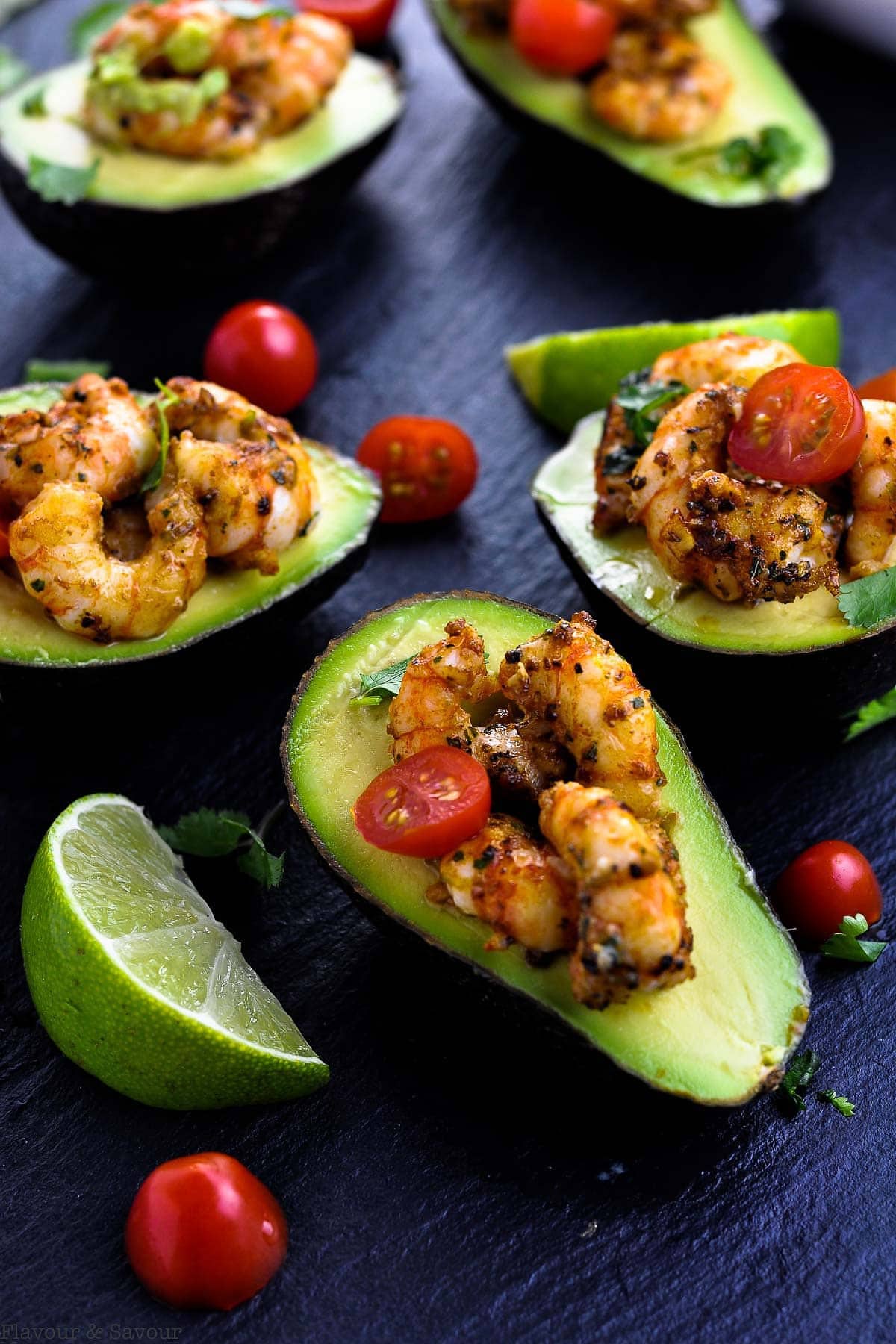 Cajun Shrimp Stuffed Avocados overhead view with cherry tomatoes and limes