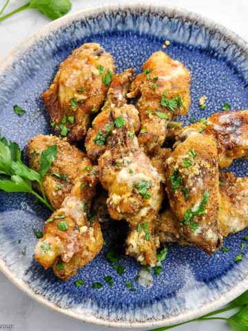 Overhead view of Air Fryer Garlic Parmesan Chicken Wings on a round blue plate