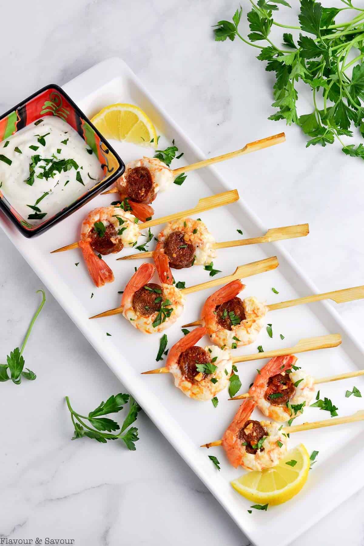 8 Prawn and Chorizo Skewer appetizers with a small dish of lemon dipping sauce.