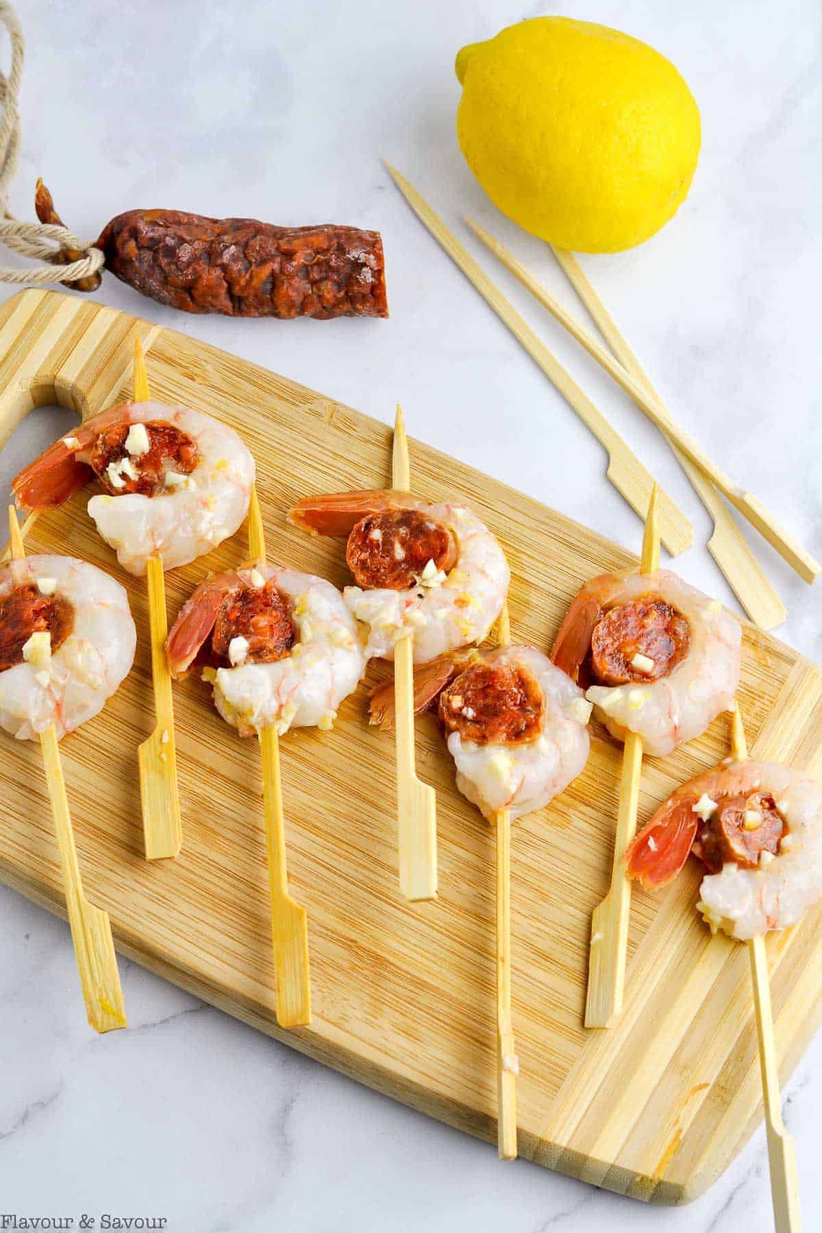 Preparing Prawn and Chorizo Skewers by threading on skewers.