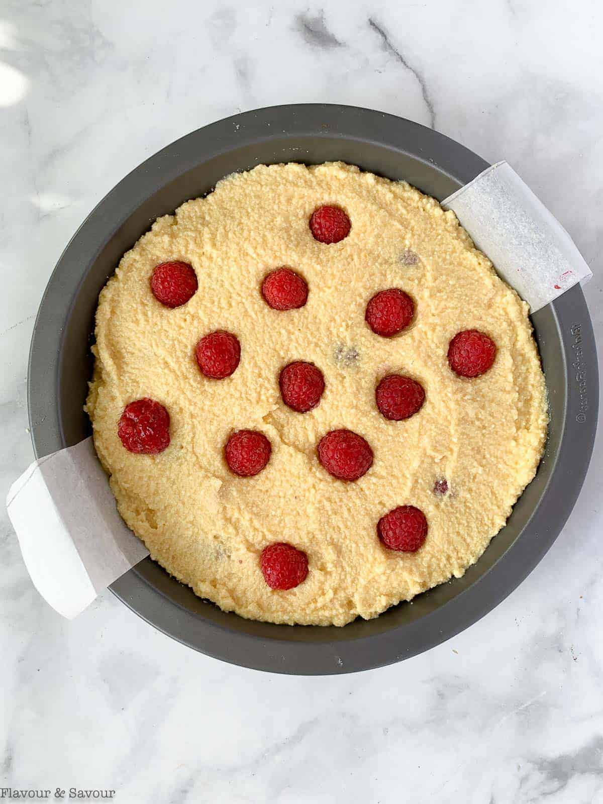 Add a final layer of raspberries to the top of the cake before baking