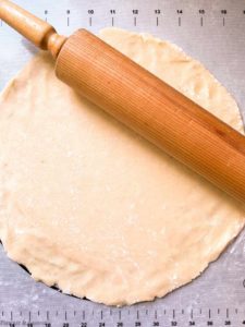 rolling out pastry dough on a pastry mat