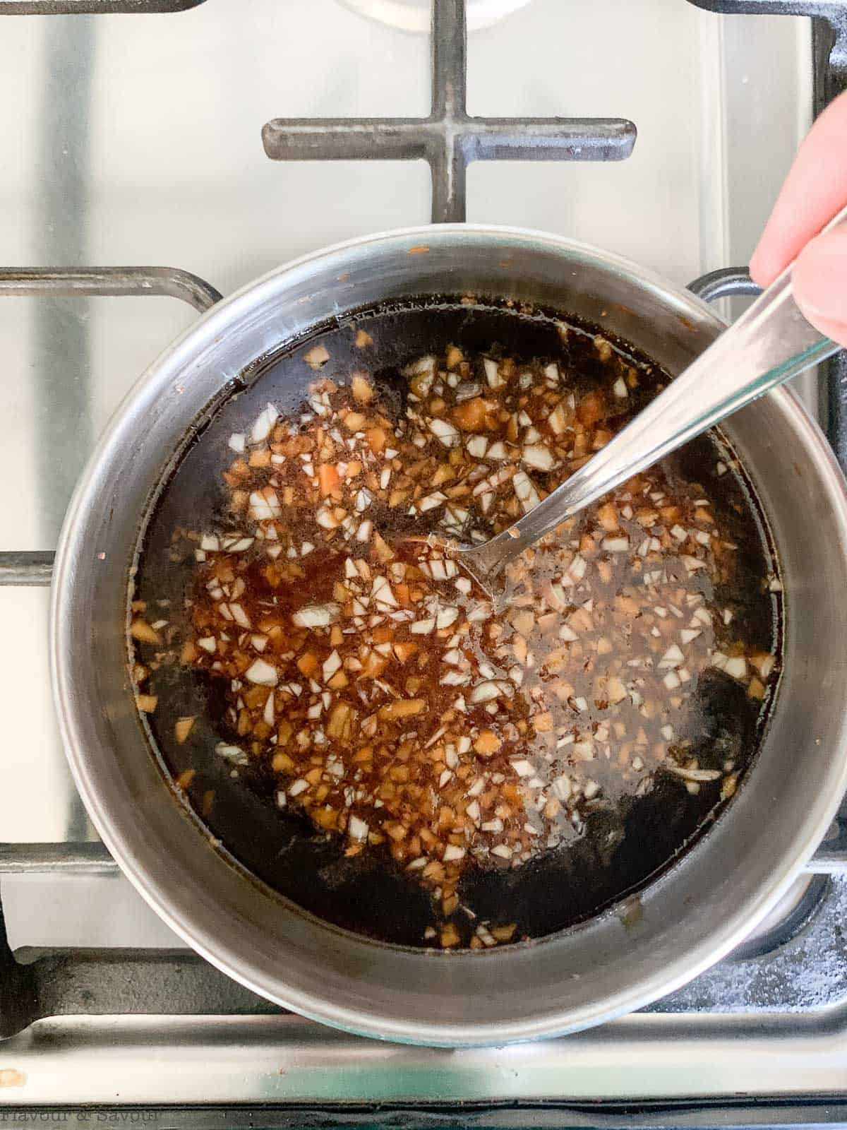 Stirring teriyaki sauce until thickened and glossy