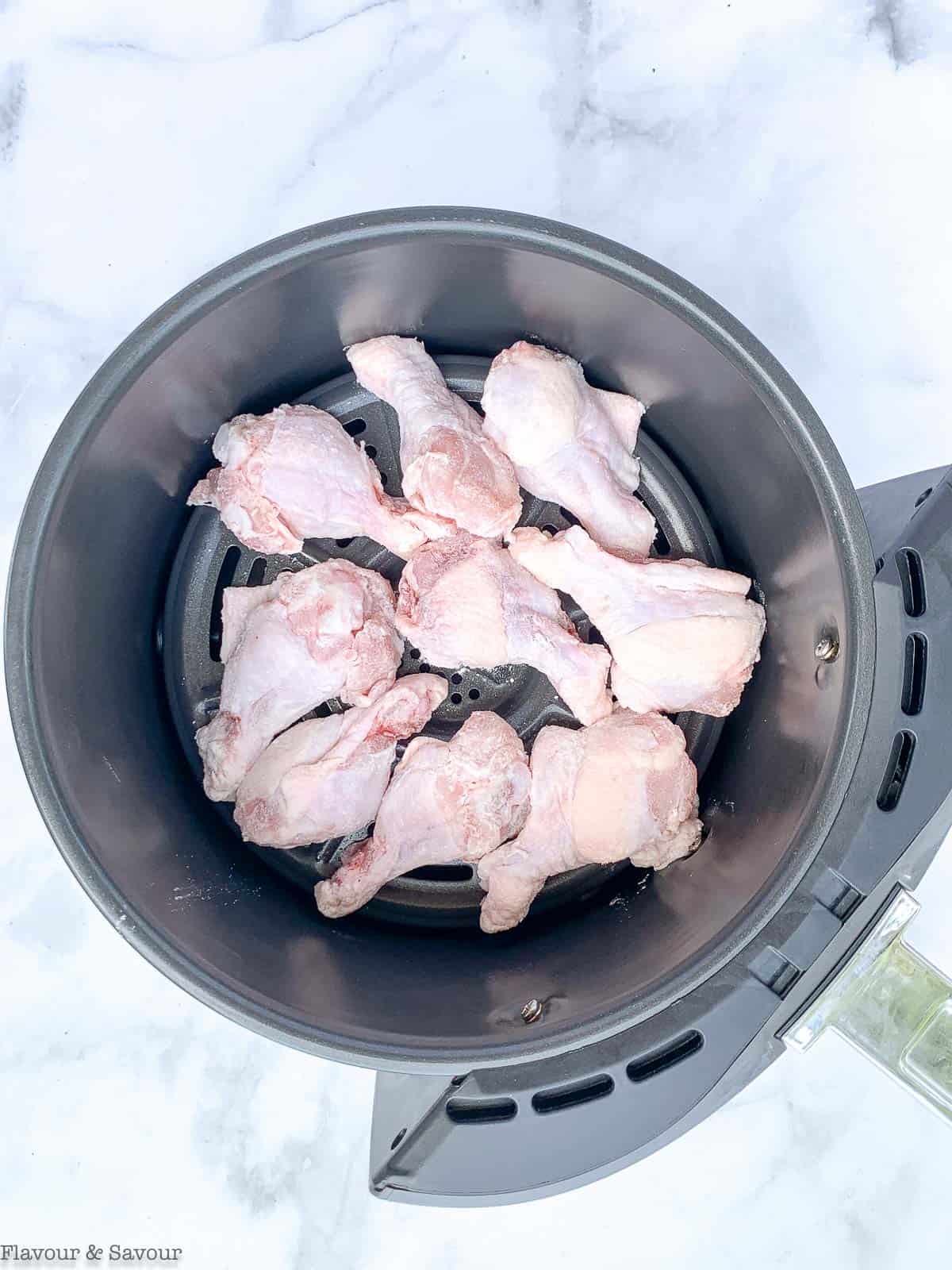 Raw Chicken Wings in an air fryer basket