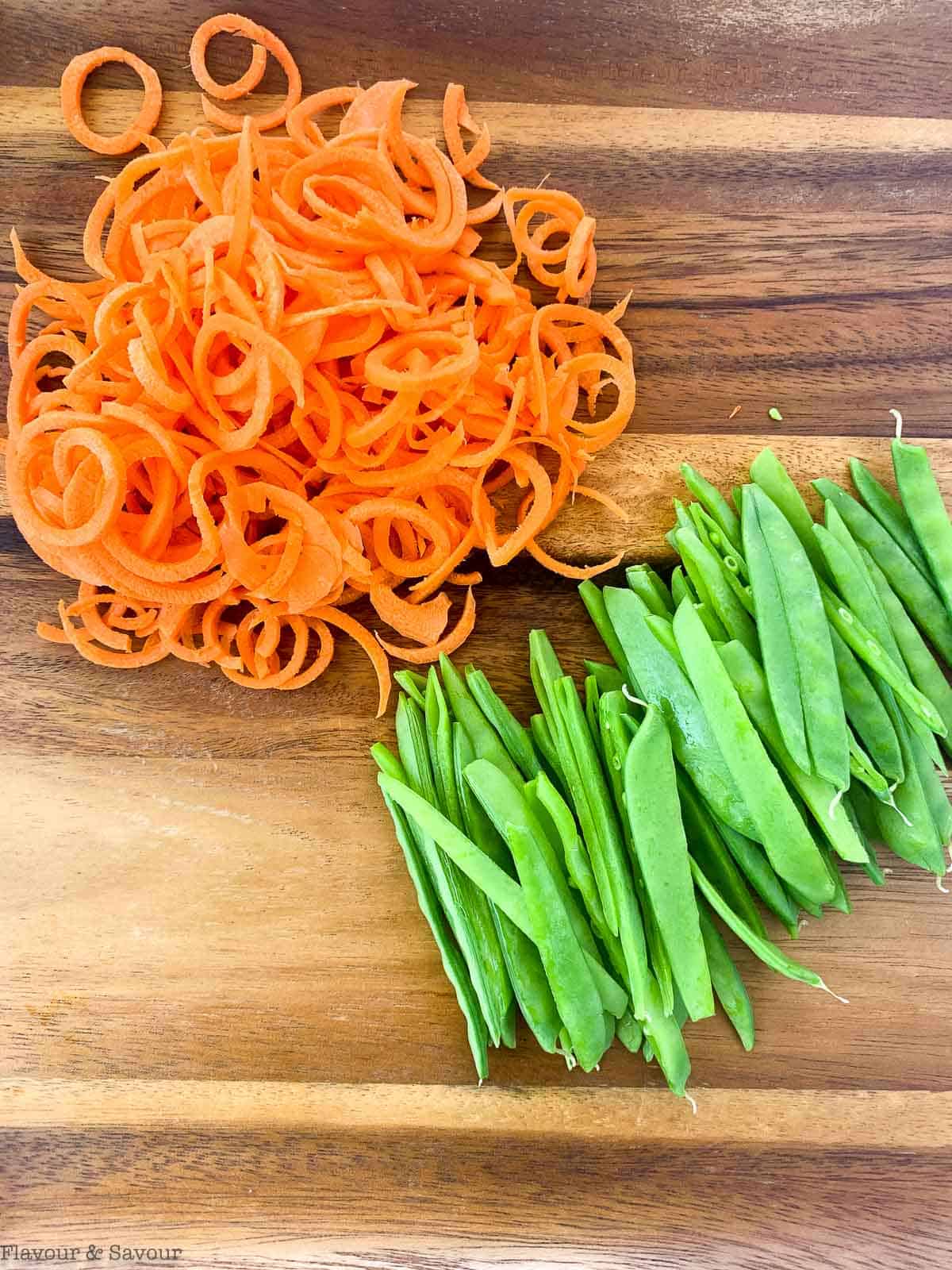 Spiralized carrots and slivered snow peas for shrimp noodle bowl.