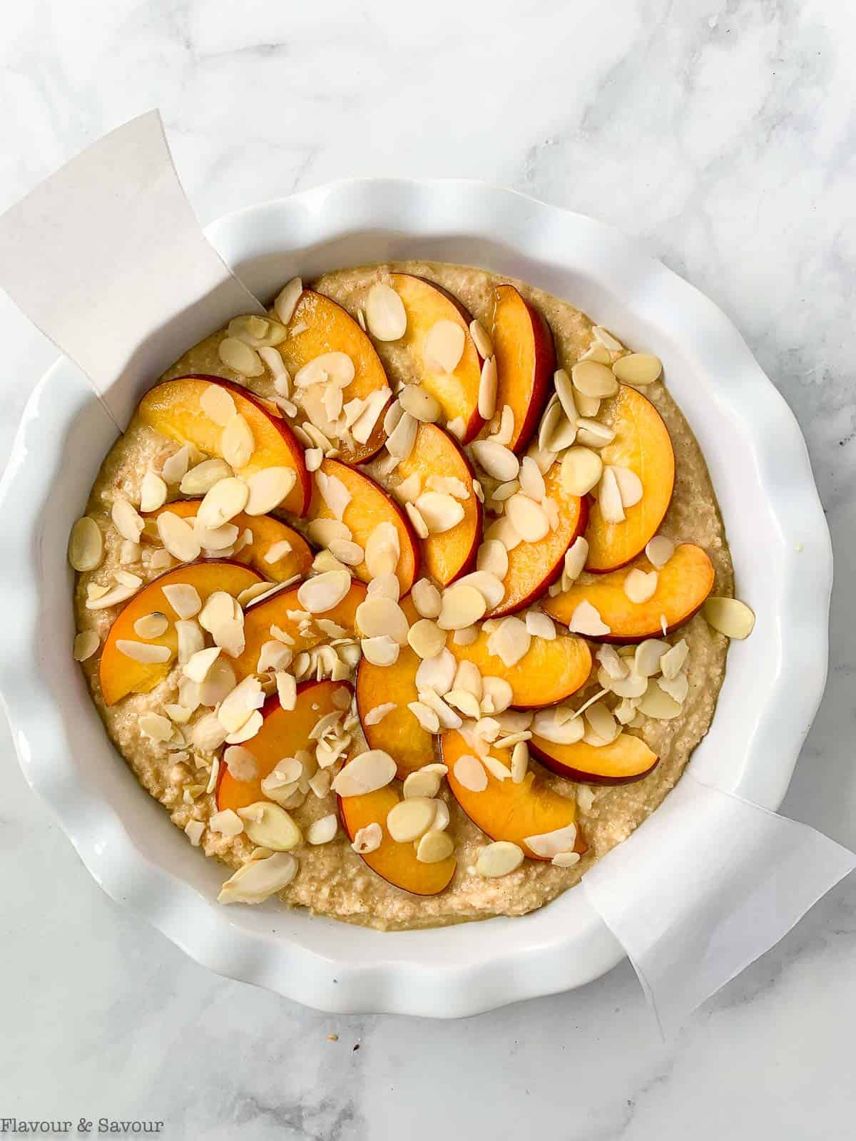 Arranging nectarine slices and almonds on top of cake