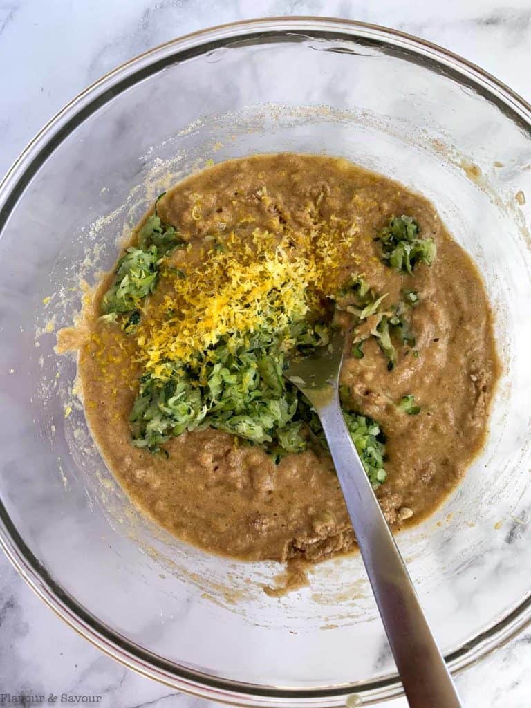 Adding zucchini and lemon zest to muffin batter.