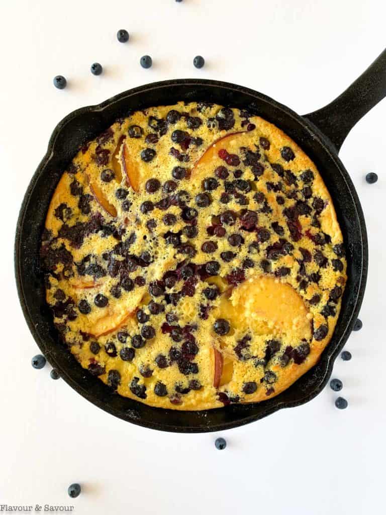 Baked Blueberry Peach Clafoutis in a cast iron skillet