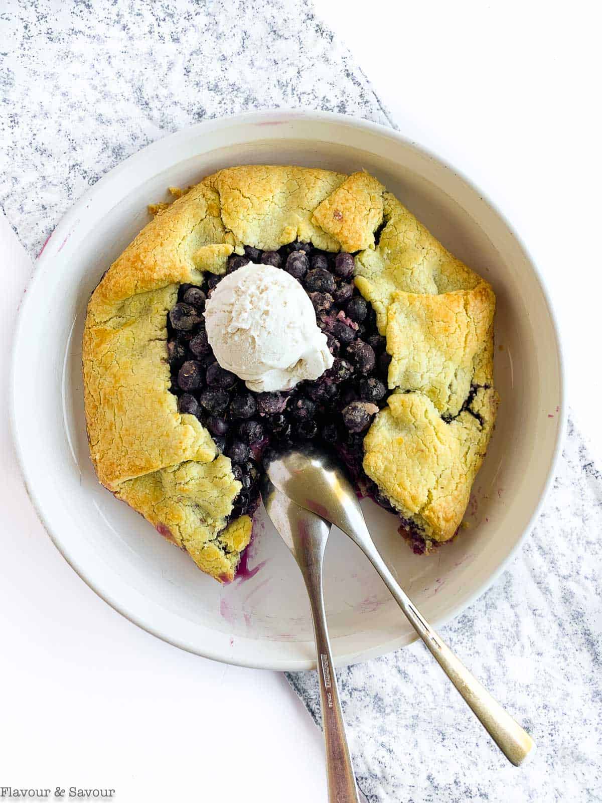 Overhead view of Blueberry Lemon Ginger Galette with a scoop of ice cream and two spoons