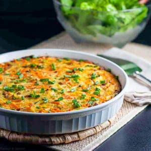 kohlrabi quiche with a bowl of green salad in the background