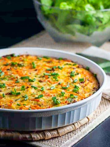 kohlrabi quiche with a bowl of green salad in the background