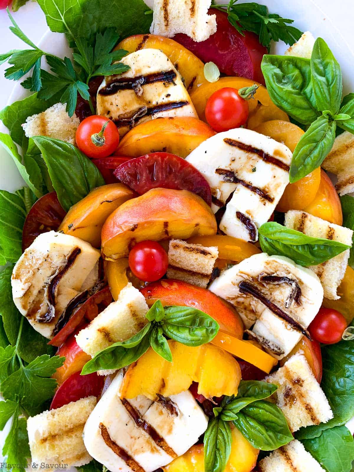 Close up view of Grilled Halloumi Peach and Tomato Salad with croutons.