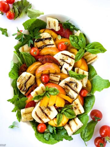 Overhead square image of grilled Halloumi Peach and Tomato Salad on a white background