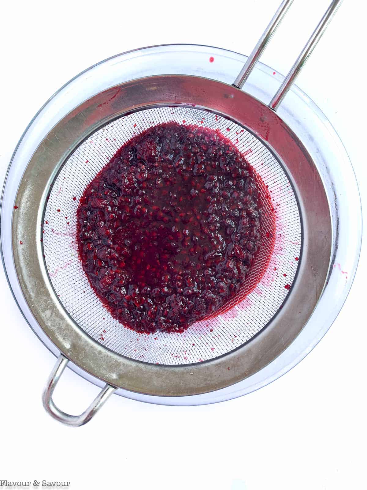 Blackberries straining in a sieve.