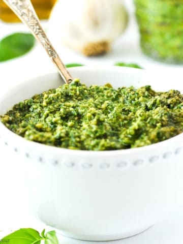 a small bowl of basil cashew pesto with a spoon