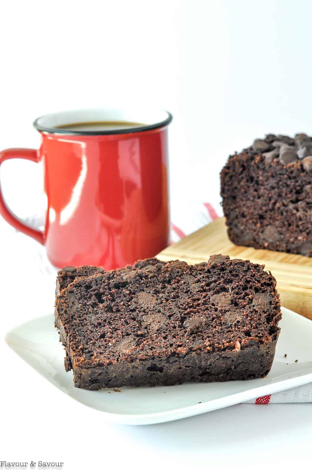 Sliced Grain-Free Double Chocolate Zucchini Bread with a mug of coffee.