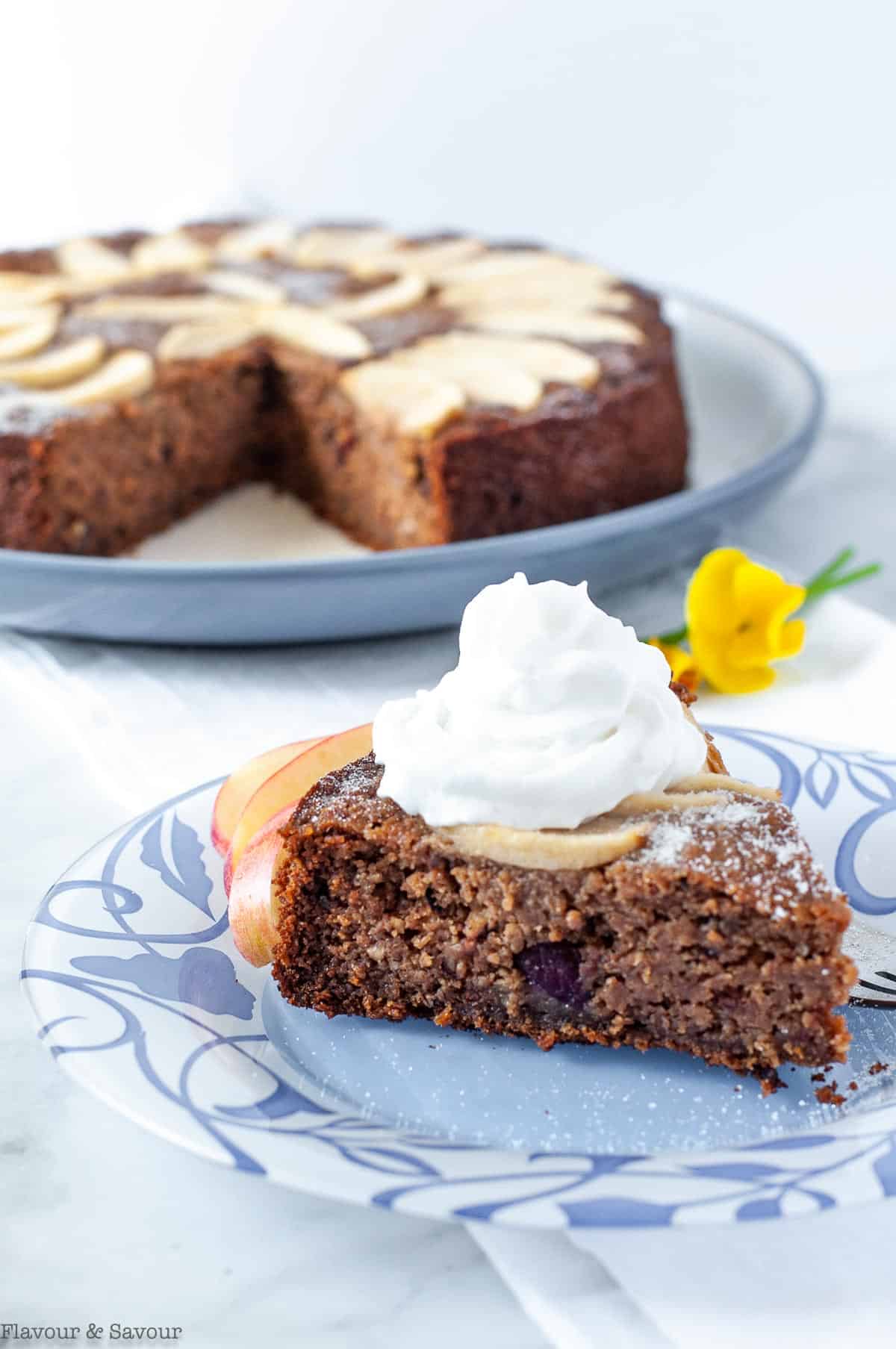 A slice of Gluten-Free Spiced Applesauce Cake with whipped coconut milk