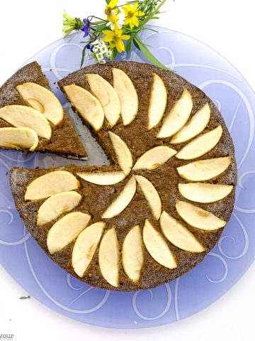 Gluten-free Spiced Applesauce Cake on a blue plate with one slice on a lifter