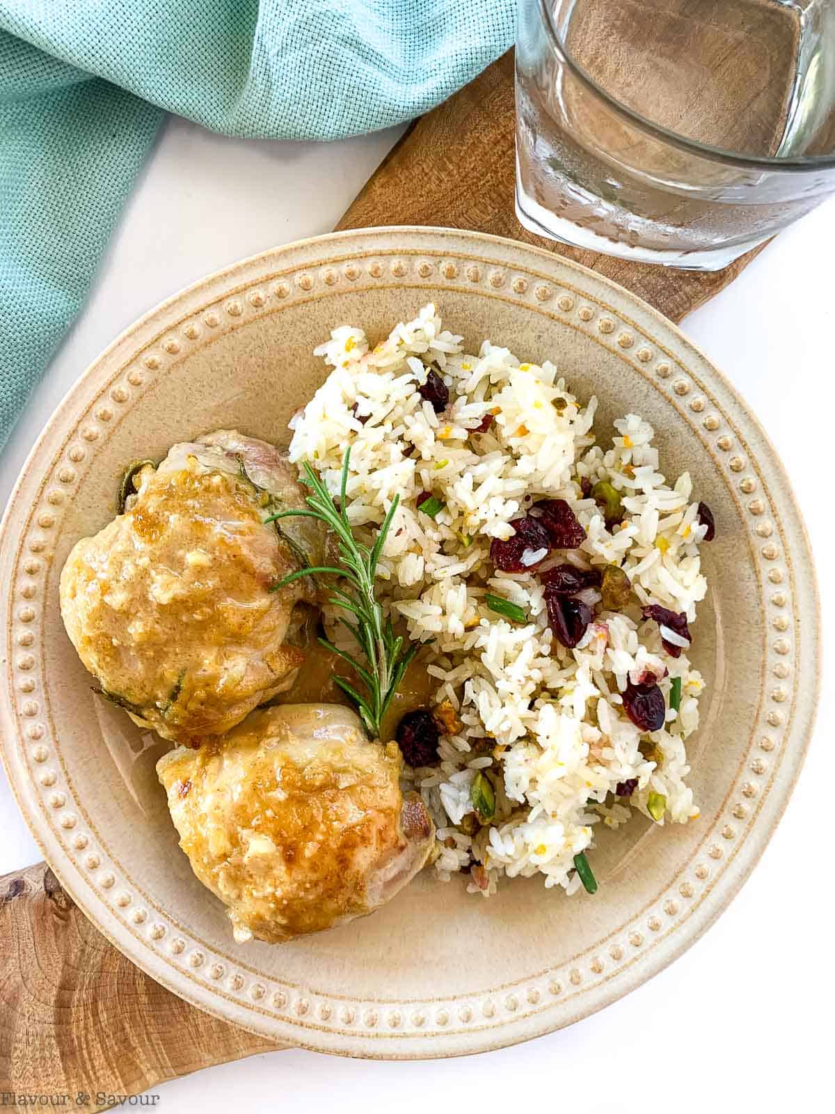 Two Maple Dijon Chicken Thighs on a plate with Cranberry Jasmine Rice.