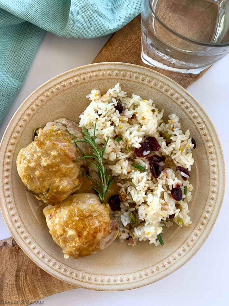 Cranberry Pistachio Jasmine Rice on a plate with chicken thighs