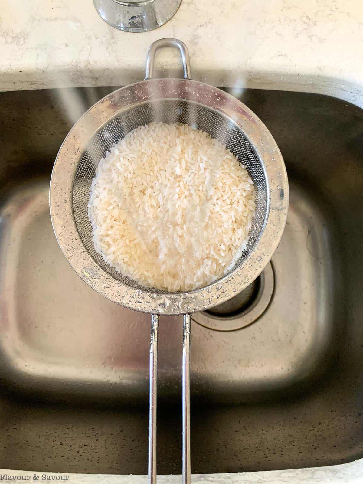 Rinsing rice through a sieve.