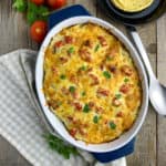 Overhead view of Salsa Verde Chicken Tortilla Casserole in a baking dish with tortillas in the background