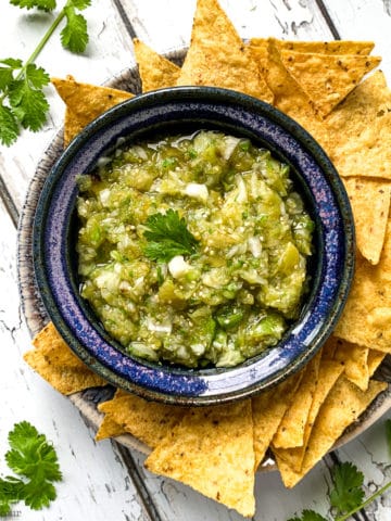 Tomatillo Salsa Verde in a blue bowl with tortilla chips