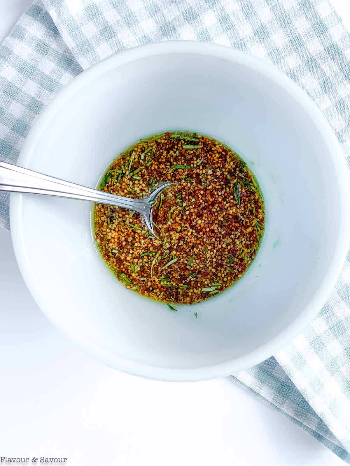 Sauce for maple dijon chicken thighs in a bowl with a spoon.